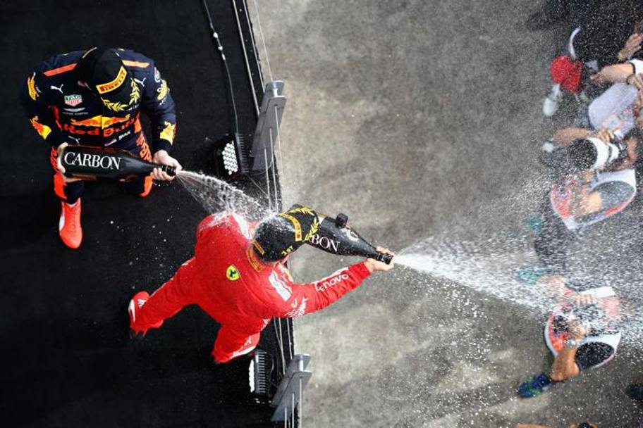 Vettel bagna tutti gi, mentre Verstappen annaffia di champagne proprio il tedesco. Afp
